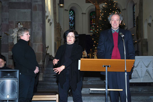 Siegfried Saerberg liest einen Blindenschrifttext und zwei Damen vom Gebärdenchor in Sankt Georg übersetzen in Gebärdensprache